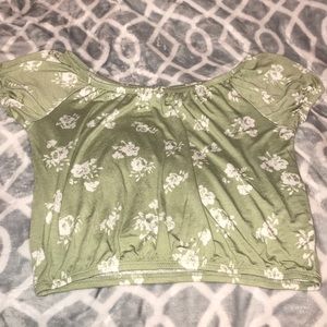 A green crop top with white flowers on it.